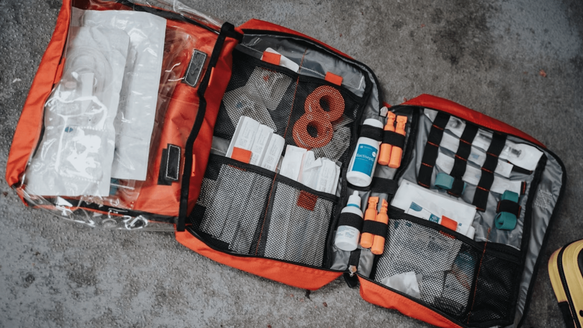 Emergency medical supply kit containing bandages, antiseptics, gloves, and medical tools.